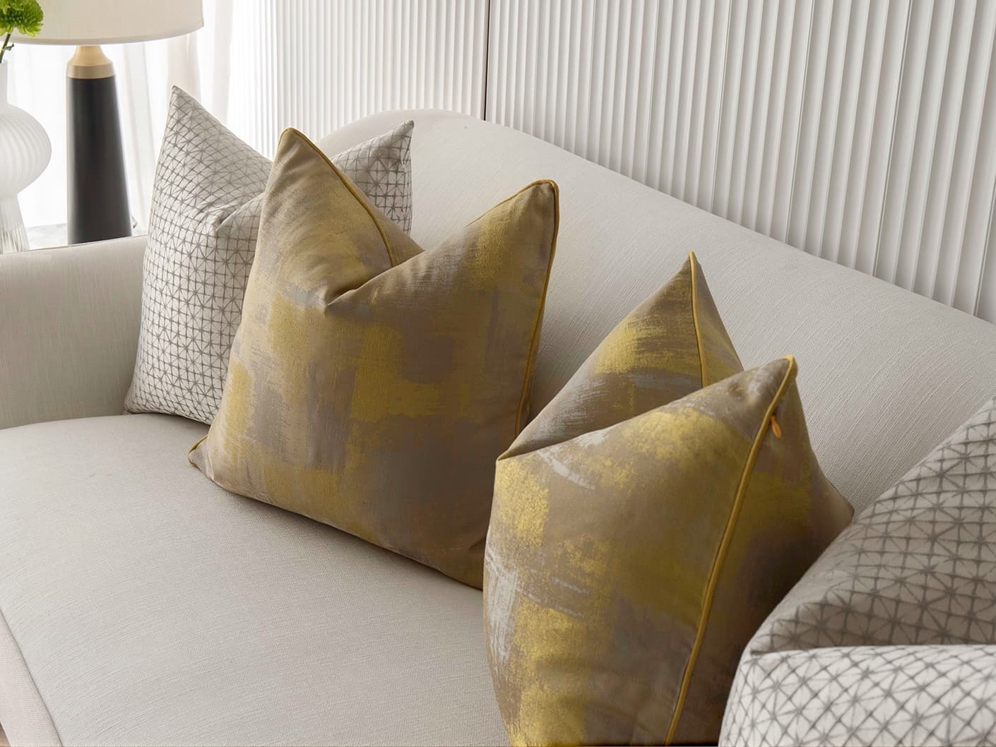 Gustave Bundle bundle cushions in silver and gold, shown in a lifestyle front view