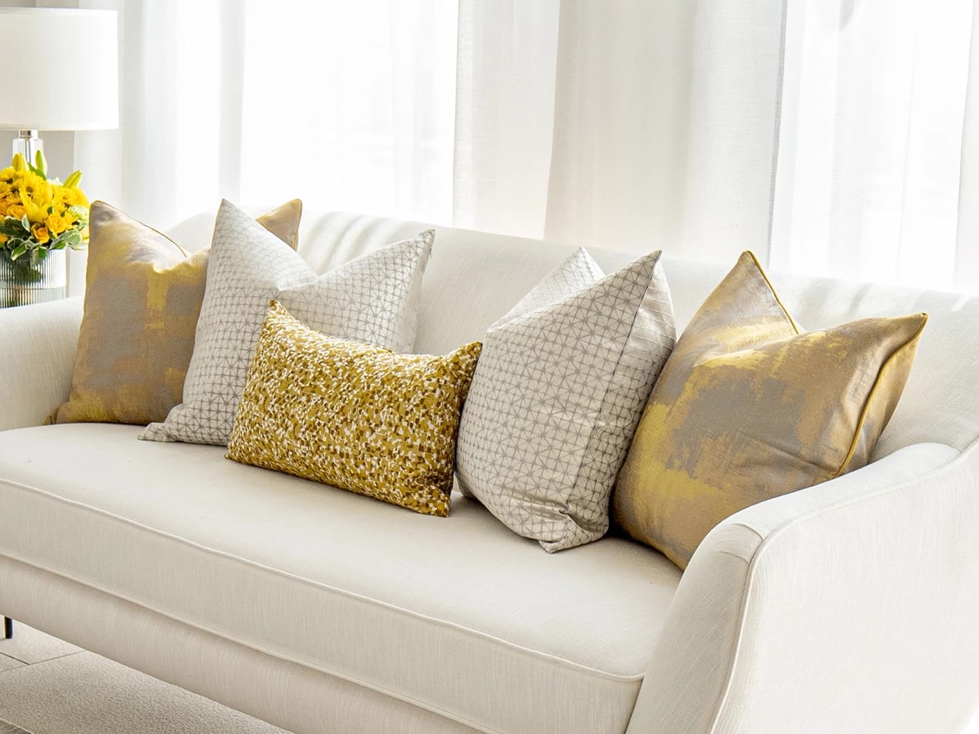 Ivan Bundle bundle cushions in gold and silver, shown in a lifestyle front view